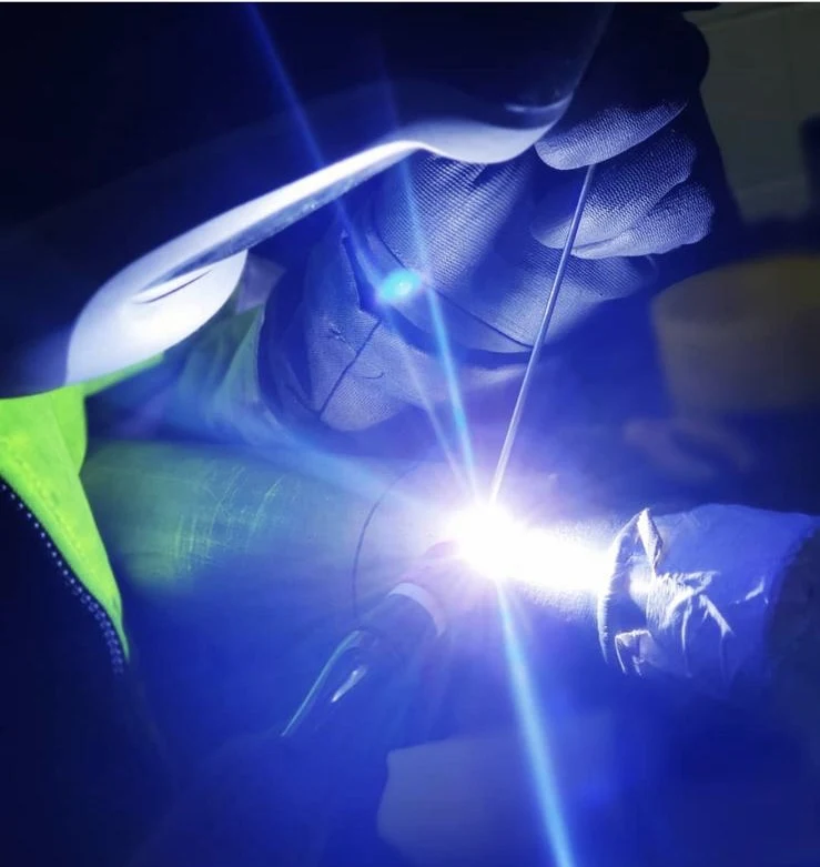 Precision TIG welding showing the torch, filler wire and bright weld pool
